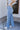 Side view of model wearing the Ceros: Charlotte Dad Jeans, which feature medium-wash-denim with light distressing, a straight let fit, and front and back pockets