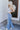 Full body side view of model wearing the Ceros: Charlotte Dad Jeans, which feature medium-wash-denim with light distressing, a straight let fit, and front and back pockets
