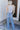 Full body back view of model wearing the Ceros: Charlotte Dad Jeans, which feature medium-wash-denim with light distressing, a straight let fit, and front and back pockets