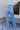 Back view of model wearing the Ceros: Charlotte Dad Jeans, which feature medium-wash-denim with light distressing, a straight let fit, and front and back pockets