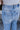 Close-up back waist view of model wearing the Ceros: Charlotte Dad Jeans, which feature medium-wash-denim with light distressing, a straight let fit, and front and back pockets
