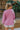 Back view of model wearing the More Self Love Sweatshirt, which has a purple colored material, a round neckline with a ribbed trim, a long sleeve, a purple and orange graphic front reading "More Self Love", and side slits