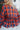 Close-up back view of model wearing the Good Life Plaid Top, which has a red material with a navy plaid print, a scoop neckline, a notched neckline with an adjustable tie, a long sleeve, and a flowy fit.