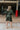 Back view of model wearing the Lost In The Moment Dress in Green, which features a forest green satin material, a collar neck, a surplice V neckline with a clasp closure, long cuffed sleeves, a knot detail at the waist, and a midi length.