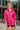 Frontal view of the Stolen Dreams Top that features a hot pink material, a collar neck and button-up front, pleated 3/4 sleeves with a bow at the wrist, and a curved bottom hem with side slits.