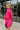 Side view of the Stolen Dreams Top that features a hot pink material, a collar neck and button-up front, pleated 3/4 sleeves with a bow at the wrist, and a curved bottom hem with side slits.