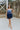 Frontal view of the Light of Your Life Mini Dress that features a tulle material, a monochromatic tiered design, a straight neckline, a sleeveless design with thin adjustable straps, a back zipper closure, and a mini length.