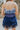 Back view of the Light of Your Life Mini Dress that features a tulle material, a monochromatic tiered design, a straight neckline, a sleeveless design with thin adjustable straps, a back zipper closure, and a mini length.
