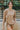 Front view of model wearing the Let's Go Top, which features a round neckline, a long sleeve, a raw curved bottom hem, and a flowy fit. Worn untucked with matching shorts.