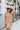 Front view of model wearing the Never Better Dress, which features a camel colored material, a faux leather collar neckline, a faux leather button-up front, short sleeves, a faux leather front pocket, and a mini length.
