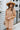 Front view of model wearing the Never Better Dress, which features a camel colored material, a faux leather collar neckline, a faux leather button-up front, short sleeves, a faux leather front pocket, and a mini length.