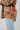 Side view of the Can't Stop Me Flannel Jacket that features a rust colored flannel material, a multi-colored plaid pattern, a brown thermal material hood with adjustable strings, a button-up front, long cuffed sleeves, a brown thermal material siding, a f