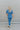 Full body back view of model wearing the Catch Up Denim Jumpsuit, that features a blue colored denim material, a collar and lapel, a surplice neckline, a short cuffed sleeve, front pockets, a button and zipper closure, side pockets, and a straight leg fit