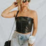 Full body front view of model wearing the Live Fast Top in Black, that has a black faux-leather material, a curved neckline, a bustier design with wiring through out, a back hook and clasp closure, and a cropped fit