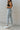 Side view of the Signature 8: Next Move Straight Leg Jeans that features a medium wash denim, a high-rise fit, a button and zipper closure, two front pockets, distressing at the knee, a raw distressed hem, two back pockets, and a straight leg fit.