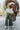 Full body front view of model wearing the Make You Mine Pants, which feature a hunter green faux-leather material, a pleated design, an elastic waist, and a wide leg fit. Worn with white top.