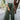 Front view of model wearing the Make You Mine Pants, which feature a hunter green faux-leather material, a pleated design, an elastic waist, and a wide leg fit. Worn with white top.