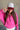 Front view of model wearing the Breast Cancer Gear: You Can Do It Trucker Hat that has a burgundy bill and back, a snapback, pink trim, and a cream front with an embroidered pink and burgundy graphic. 