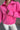 Close front view of model wearing the Hot Pink Quarter-Zip Sweatshirt that has hot pink knit fabric with a soft fleece interior, long raglan sleeves, a quarter-zip front with a high neck, and a kangaroo pocket.