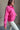 Side view of model wearing the Hot Pink Quarter-Zip Sweatshirt that has hot pink knit fabric with a soft fleece interior, long raglan sleeves, a quarter-zip front with a high neck, and a kangaroo pocket.