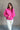 Front view of model wearing the Hot Pink Quarter-Zip Sweatshirt that has hot pink knit fabric with a soft fleece interior, long raglan sleeves, a quarter-zip front with a high neck, and a kangaroo pocket.
