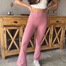 Front view of model wearing the Carmen Flared Leggings in Mauve that has soft dusty mauve fabric, a high waistline, and flared legs
