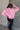 back view of model wearing the Catherine Pink Heathered Mock Neck Sweater that has pink and white heather knit fabric, ribbed hem, a high neck, and long balloon sleeves with cuffs.