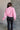 Back view of model wearing the Catherine Pink Heathered Mock Neck Sweater that has pink and white heather knit fabric, ribbed hem, a high neck, and long balloon sleeves with cuffs.