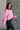 Side view of model wearing the Catherine Pink Heathered Mock Neck Sweater that has pink and white heather knit fabric, ribbed hem, a high neck, and long balloon sleeves with cuffs.