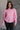 front view of model wearing the Catherine Pink Heathered Mock Neck Sweater that has pink and white heather knit fabric, ribbed hem, a high neck, and long balloon sleeves with cuffs.