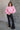 Full body front view of model wearing the Catherine Pink Heathered Mock Neck Sweater that has pink and white heather knit fabric, ribbed hem, a high neck, and long balloon sleeves with cuffs.