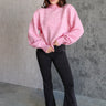 Full body front view of model wearing the Catherine Pink Heathered Mock Neck Sweater that has pink and white heather knit fabric, ribbed hem, a high neck, and long balloon sleeves with cuffs.