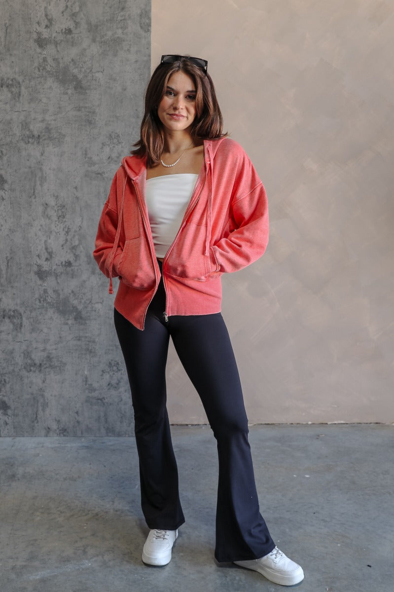 Full body front view of model wearing the Lauren Washed Red Zip-Up Hoodie Sweatshirt that has two pockets, a silver zipper, a hood with drawstrings, dropped shoulders, and long sleeves with cuffs.