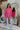 Full body front view of model wearing the Take My Hand Sweater that has hot pink loose-knit fabric, a high-low hem, a round neck, and 3/4 batwing sleeves with cuffs