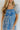 Close front view of model wearing the Forget Me Not Babydoll Dress that has blue and light blue organza fabric with a floral pattern, a mini-length hem, a square neck, a back zipper with a hook closure, and short puff sleeves