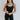 Front view of model wearing the Can You Keep Up Bodysuit that features black stretch fabric, a round neckline, adjustable thick straps, and fitted shorts.