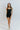 Full body front view of model wearing the Can You Keep Up Bodysuit that features black stretch fabric, a round neckline, adjustable thick straps, and fitted shorts.