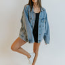 Full body front view of model wearing the Too Good To Be True Denim Jacket that has an oversized fit, medium-wash denim, a button-up front with a collar, chest pockets, side pockets, and long sleeves.