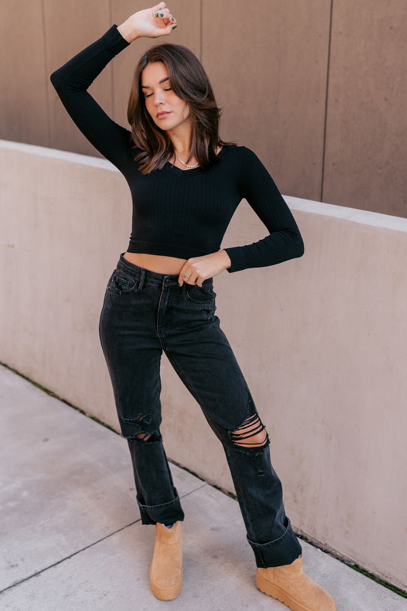Full body view of model wearing the Judy Blue: Alicia Black Straight Leg Jeans which features washed black denim, two front pockets, two back pockets, front zipper with button closure, belt loops, distressed details, busted knee details and straight pant 