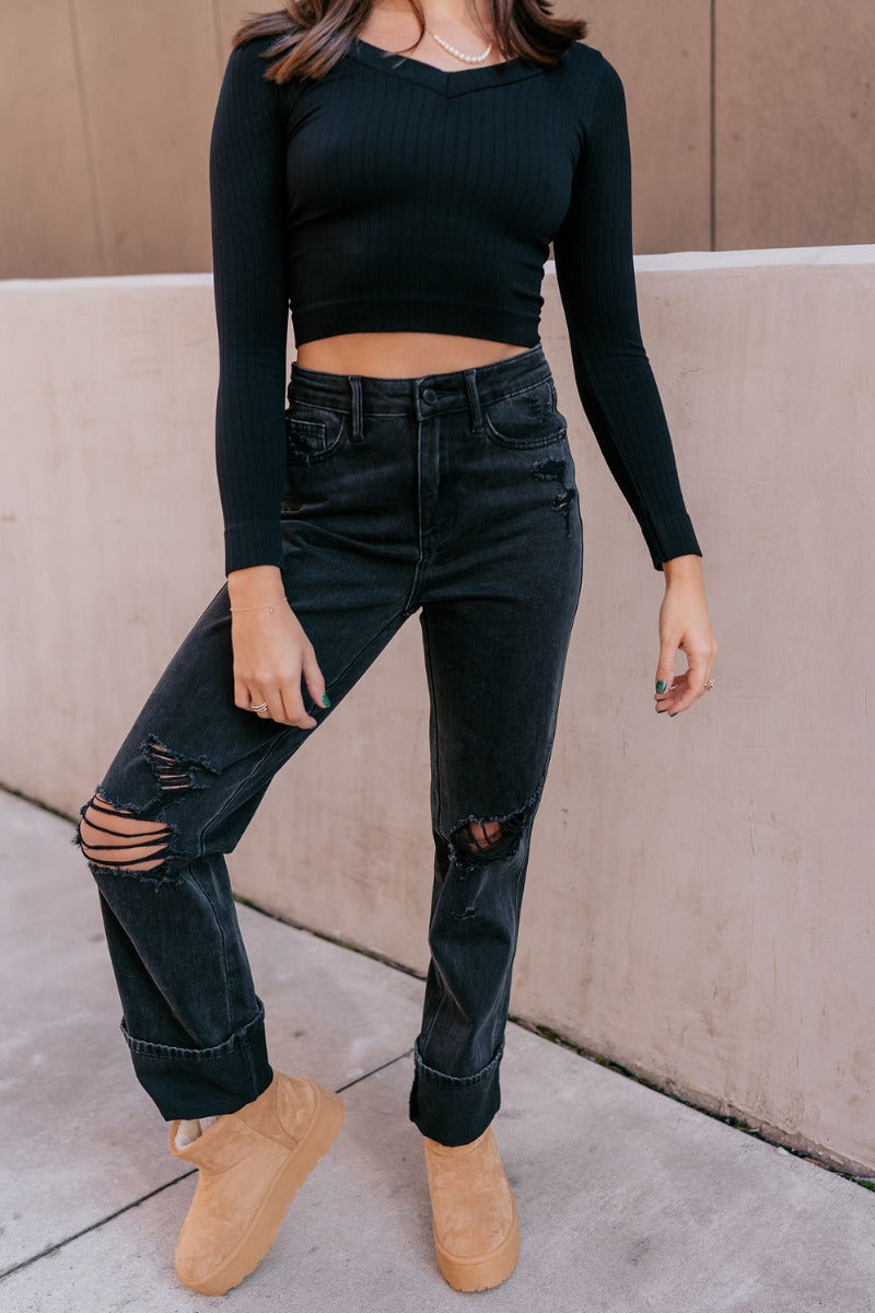 Front view of model wearing the Judy Blue: Alicia Black Straight Leg Jeans which features washed black denim, two front pockets, two back pockets, front zipper with button closure, belt loops, distressed details, busted knee details and straight pant legs