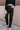 front view of model wearing the Alexis Black Faux Leather Pants which features black faux leather, front zipper with button closure, two front pockets, two back pockets, belt loops and wide pant legs.