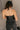 Back view of model wearing  the Stella Black Faux Leather Strapless Top which features black faux leather, ruched sides, a cropped waist, a strapless sweetheart neckline, and a back zipper.