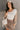 Front view of model wearing the Journey Mocha Brown Cargo Mini Skirt which features taupe brown textured soft fabric, two fornt cargo pocket with zipper closure, elastic waistband with tie and mini length.