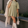 Full body view of model wearing the Leah Light Olive Short Sleeve Mini Dress which features light olive knit fabric, oversized peplum body, raw hem details, round neckline and short sleeves.