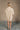 full body back view of model wearing the Isabella Cream Turtleneck Sweater Dress that has cream cable knit fabric, ribbed trim, mini length, a turtleneck, dropped shoulders, and long balloon sleeves with ribbed cuffs.