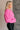 Side view of model wearing the Clara Fuchsia Knit Button Snap Up Long Sleeve Sweater which features hot pink knit fabric, cropped waist, button snap up closure, collared neckline and long sleeves with cuffs.