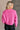 Back view of model wearing the Clara Fuchsia Knit Button Snap Up Long Sleeve Sweater which features hot pink knit fabric, cropped waist, button snap up closure, collared neckline and long sleeves with cuffs.