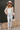 Full body view of model wearing the Stephanie Beige & White Checkered Sherpa Shacket which features beige and white textured fabric, checkered print, two front slip pockets, hidden button snaps, collared neckline and long sleeves.