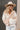 Front view of model wearing the Stephanie Beige & White Checkered Sherpa Shacket which features beige and white textured fabric, checkered print, two front slip pockets, hidden button snaps, collared neckline and long sleeves.