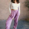 Full body view of model wearing the Myla Vintage Purple Drawstring Jogger Pants which features light purple waffle knit fabric, two front pockets, an elastic waistband with drawstring ties, and jogger pant legs with thick hem.
